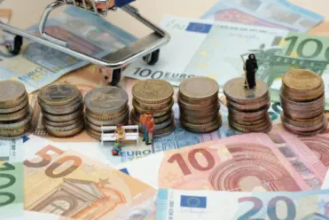 Geldschein und Münzen liegen auf einem Tisch