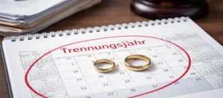 Kalender liegt auf einem Tisch und darauf zwei Eheringe