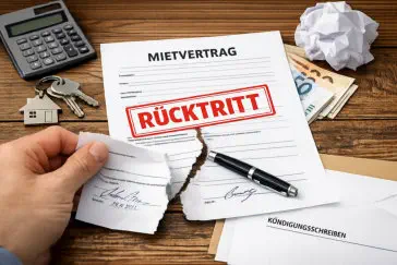 Zerrissener Mietvertrag mit rotem „Rücktritt“-Stempel auf Holztisch, daneben Schlüssel, Taschenrechner, Geldscheine und Kündigungsschreiben – Symbolbild für den Rücktritt vom unterschriebenen Mietvertrag. 